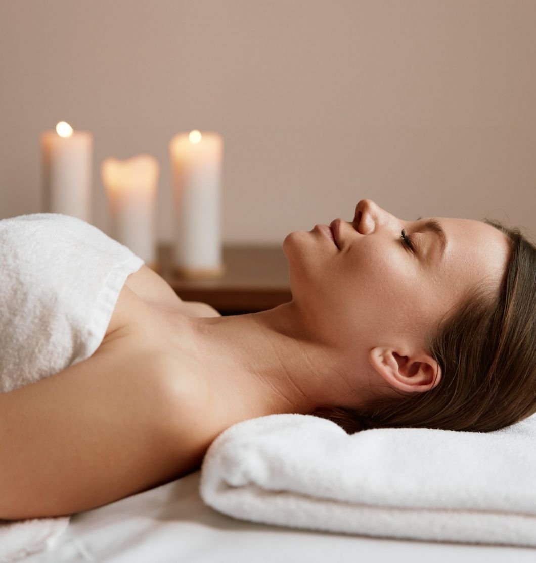 Side view of peaceful woman relaxing in spa salon after massage